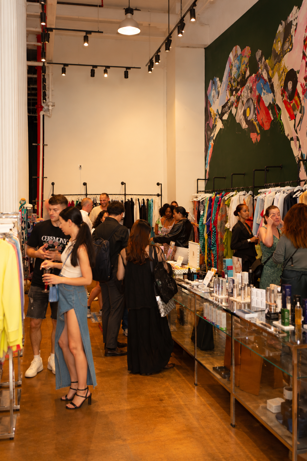 Guests browse clothing collections in a designer showroom.